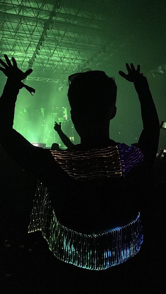 Lloyd dancing under green stage lights, arms raised